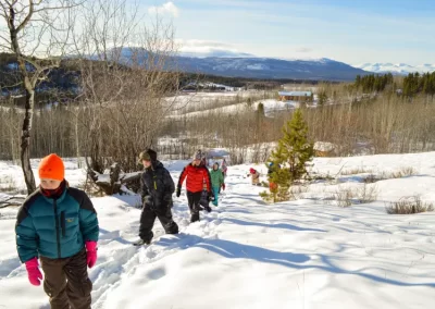 Kids in snowsuits exploring the Yukon Wildlife Preserve during March Break Camps.